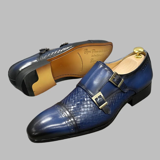 Blue leather monk strap men's dress shoes with woven pattern and double buckles on gray background