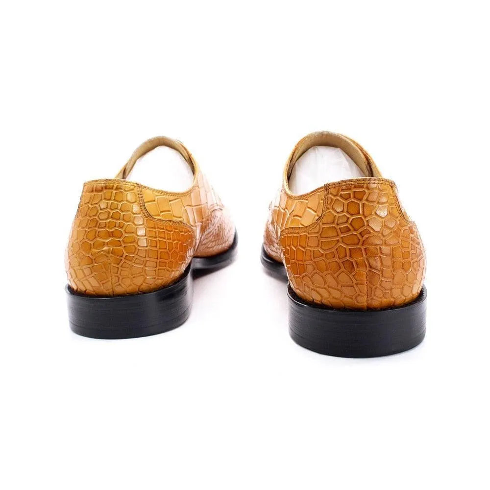 Tan crocodile pattern leather men's dress shoes with black soles on white background