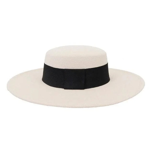 Beige derby fedora hat with wide black band and flat brim on white background