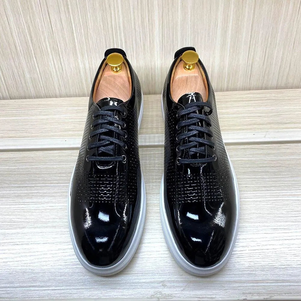 Glossy black leather dress sneakers with white soles on a light wooden surface