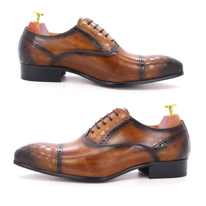 Brown leather lace-up men's dress shoes with brogue detailing on white background