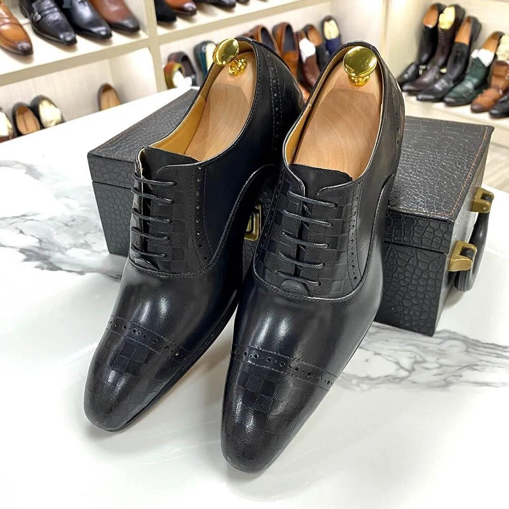 Black leather men's dress shoes with lace-up design on a marble table, shoe rack in background