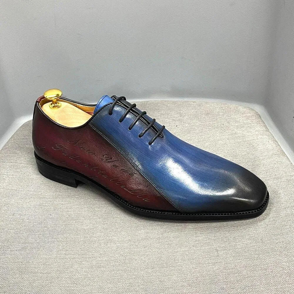 Men's color block dress shoe with blue, burgundy, and black leather, lace-up, on gray fabric