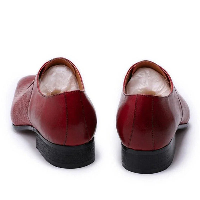 Back view of red leather men's dress shoes with low black heels on white background