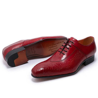 Red leather men's dress shoes with textured pattern and black laces on white background