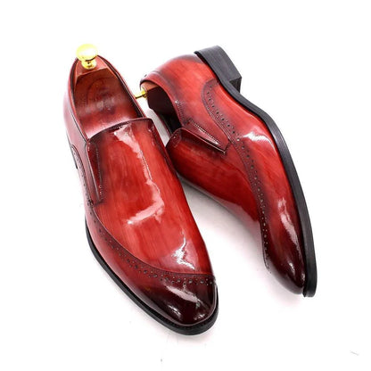 Glossy red men's dress shoes slip-on style with black soles on white background