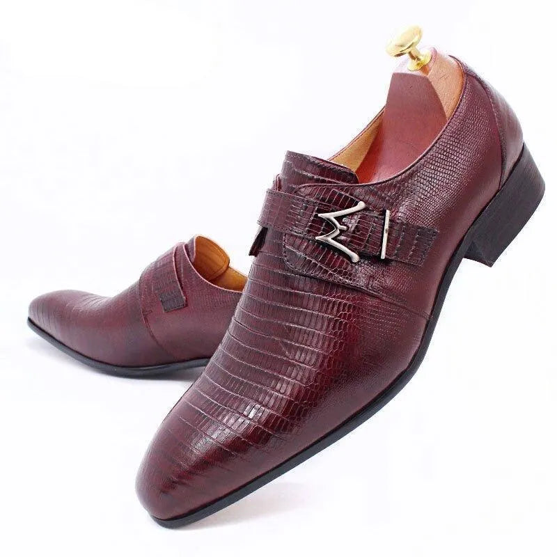 Burgundy lizard-pattern leather men's dress shoes with metal buckle detail on white background