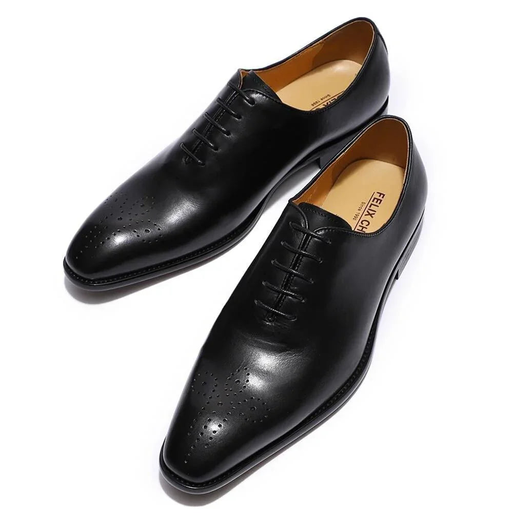 Black leather men's oxford dress shoes with perforated toe detail on white background