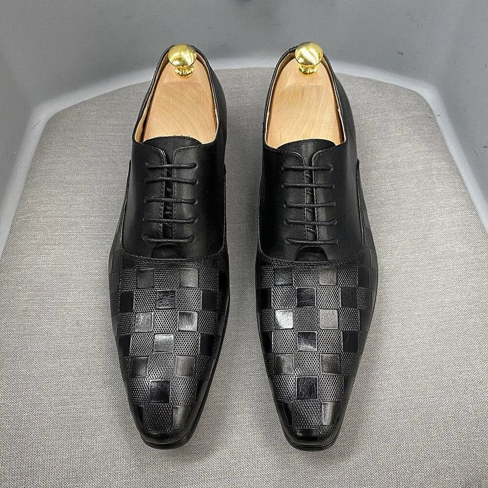 Black checked leather men's dress shoes with lace-up design on a grey chair