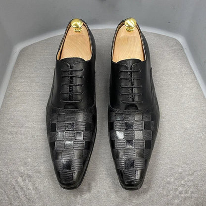 Black checked leather men's dress shoes with lace-up design on a grey chair