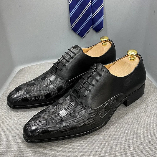 Black men's dress shoes with checked pattern on toe, displayed with a blue striped tie
