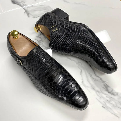 Black snakeskin-pattern leather men's dress shoes on marble background