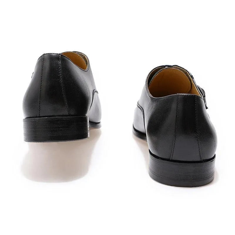 Rear view of classic black leather men’s dress shoes on white background