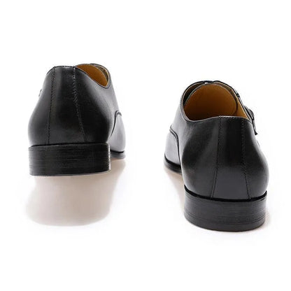 Rear view of classic black leather men’s dress shoes on white background
