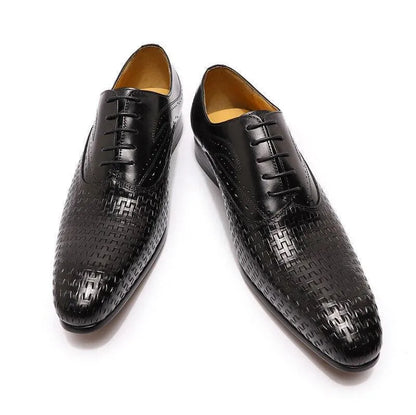 Black leather pointed-toe dress shoes with textured woven pattern on white background