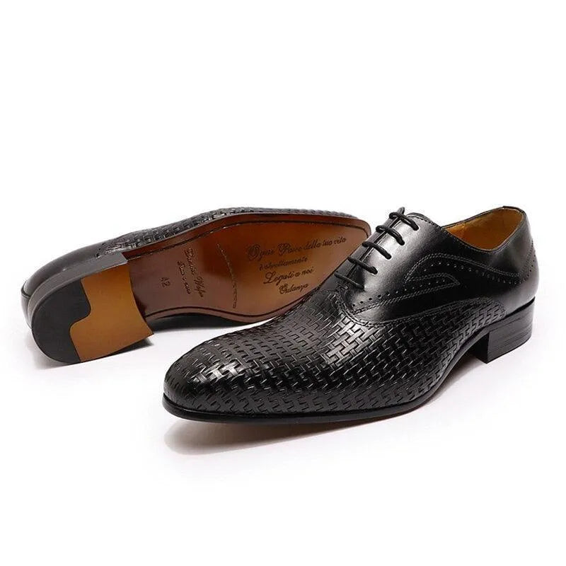 Black leather pointed-toe dress shoes with woven pattern on a white background