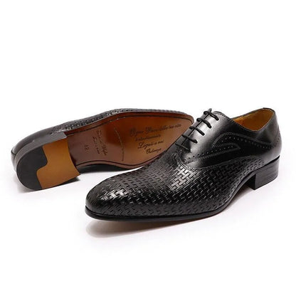 Black leather pointed-toe dress shoes with woven pattern on a white background
