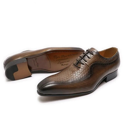 Brown leather men's dress shoes with pointed toe and embossed pattern on white background