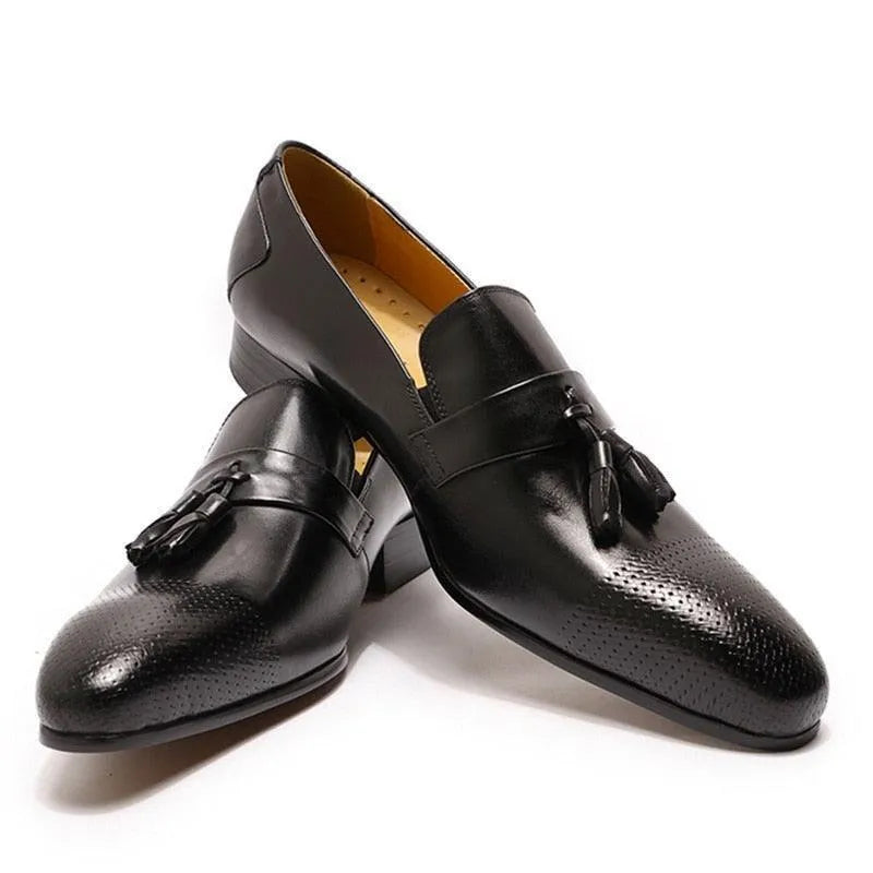Black leather tassel dress shoes for men with perforated toe detail on white background
