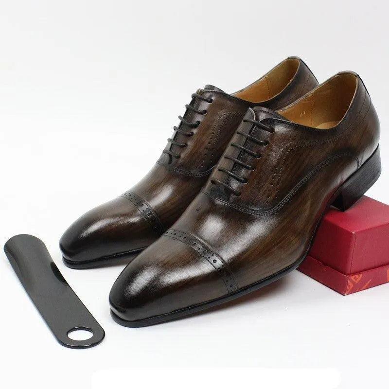 Brown leather men's dress shoes with lace-up design, shoehorn, and red box on white background