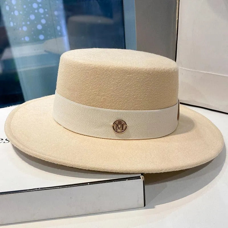 Elegant beige fedora hat for women with flat top and white band on display table