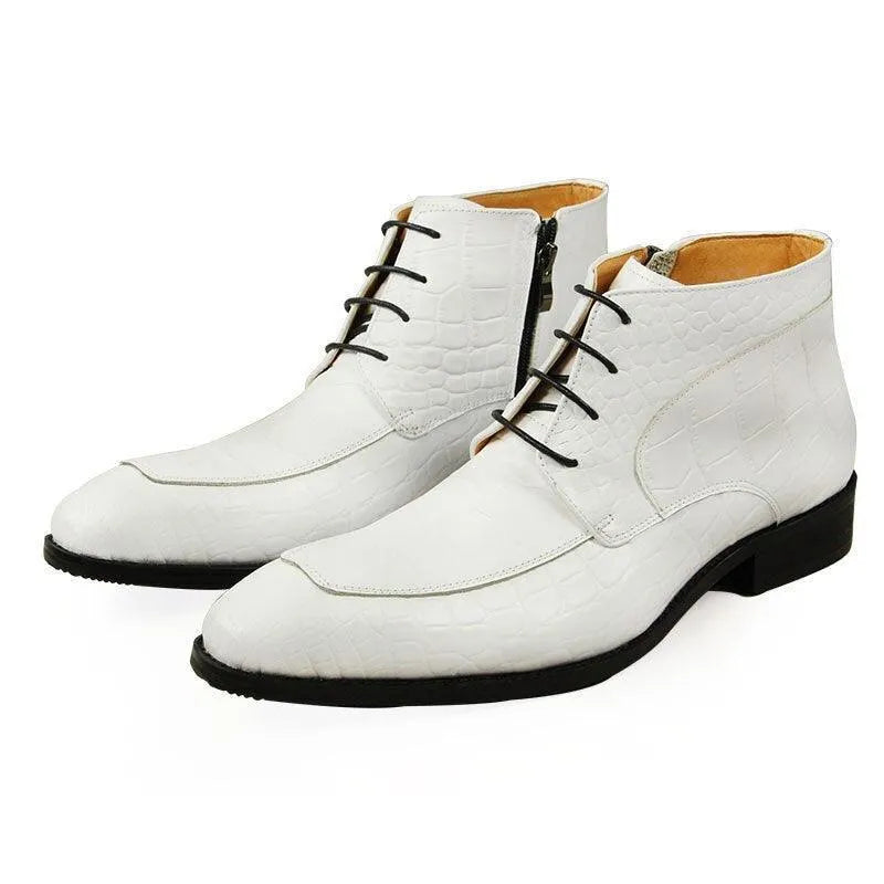 White leather ankle boots with crocodile texture and black laces on a white background