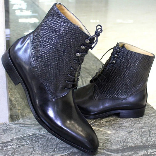 Black leather ankle boots with textured upper, lace-up design on a marble floor