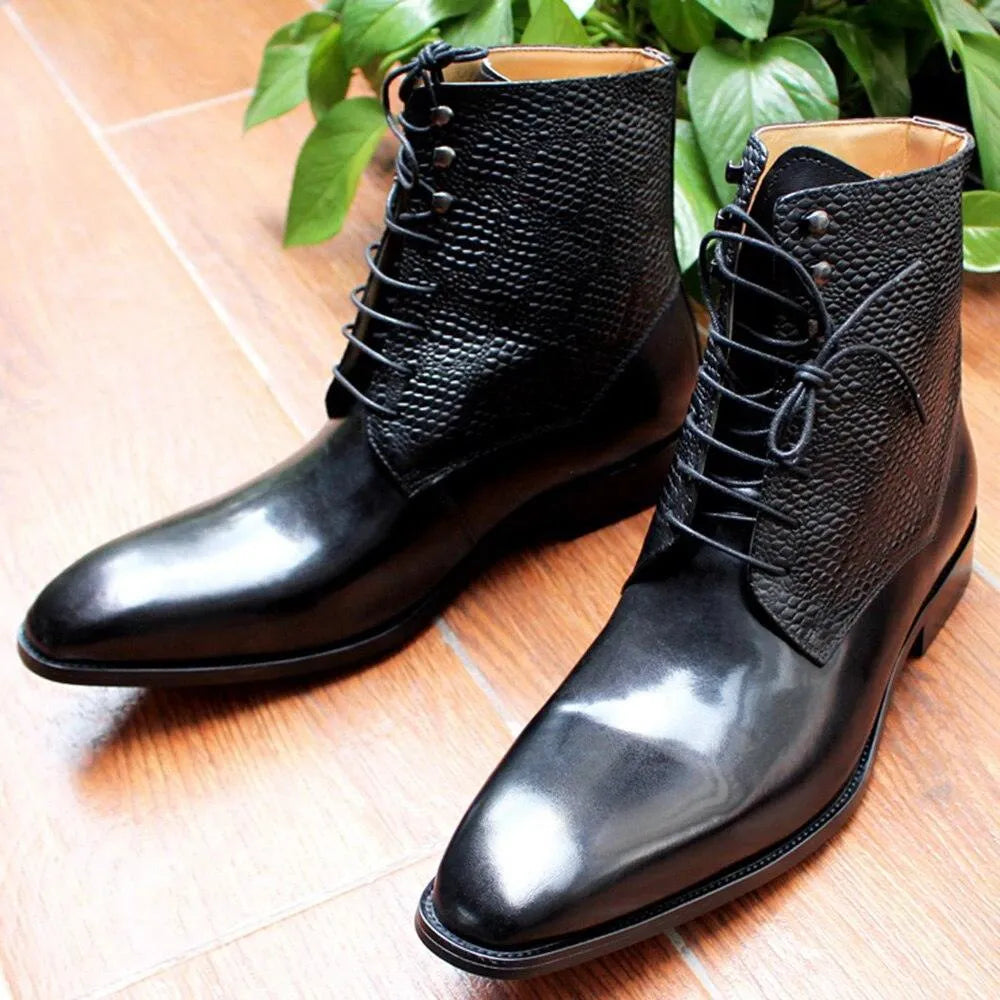 Black leather ankle boots with textured uppers on wooden floor, green plant in background