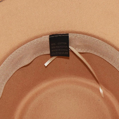Close-up of beige fedora hat interior with care tag, cotton polyester blend label.