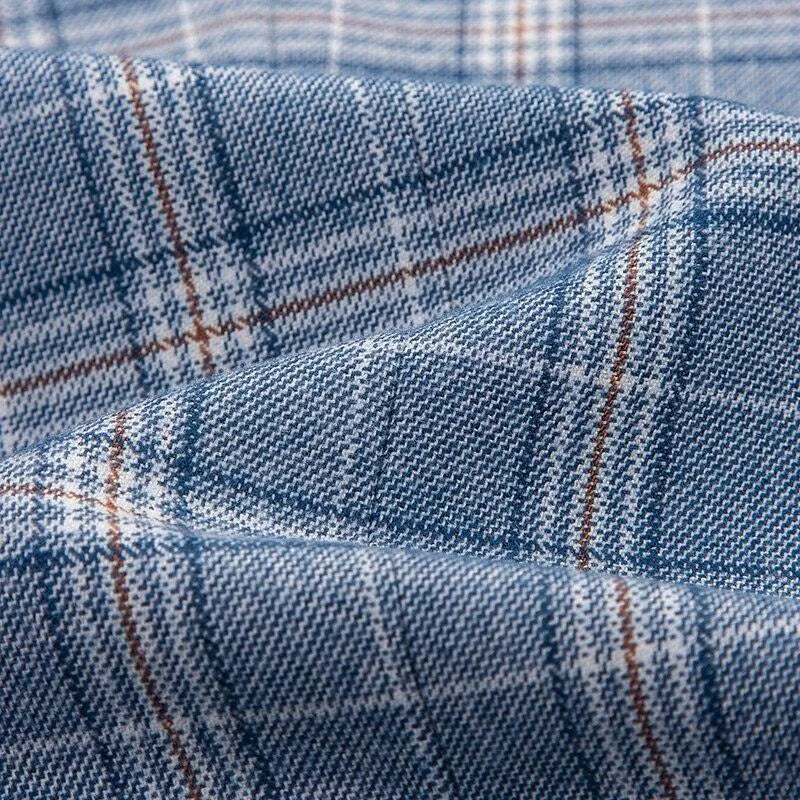 Blue grey plaid suit fabric with white and brown lines, close-up texture view