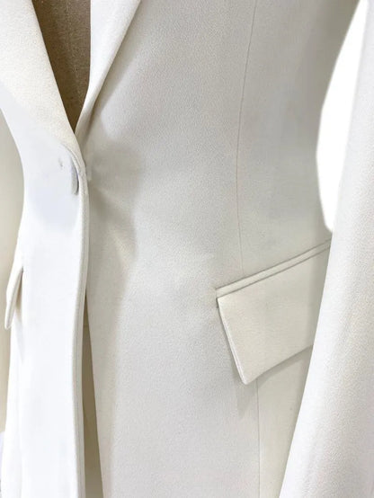 Close-up of white women’s tailored pantsuit jacket with flap pocket and low neck lapel