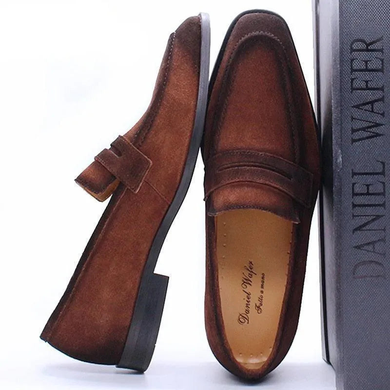 Brown suede men's dress loafers with a low heel, displayed beside a Daniel Wafer shoe box